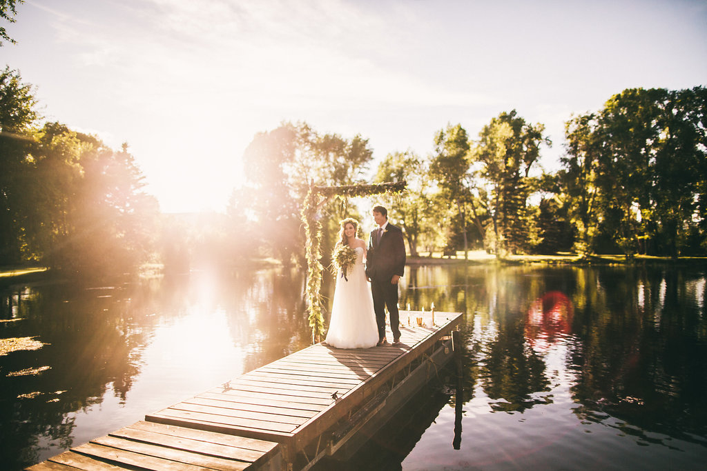Bride and groom during sunset by a lake