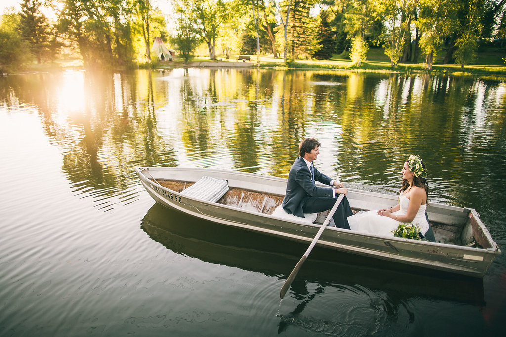 Bride and groom in row boat on a lake. Boat elopement in Colorado. 