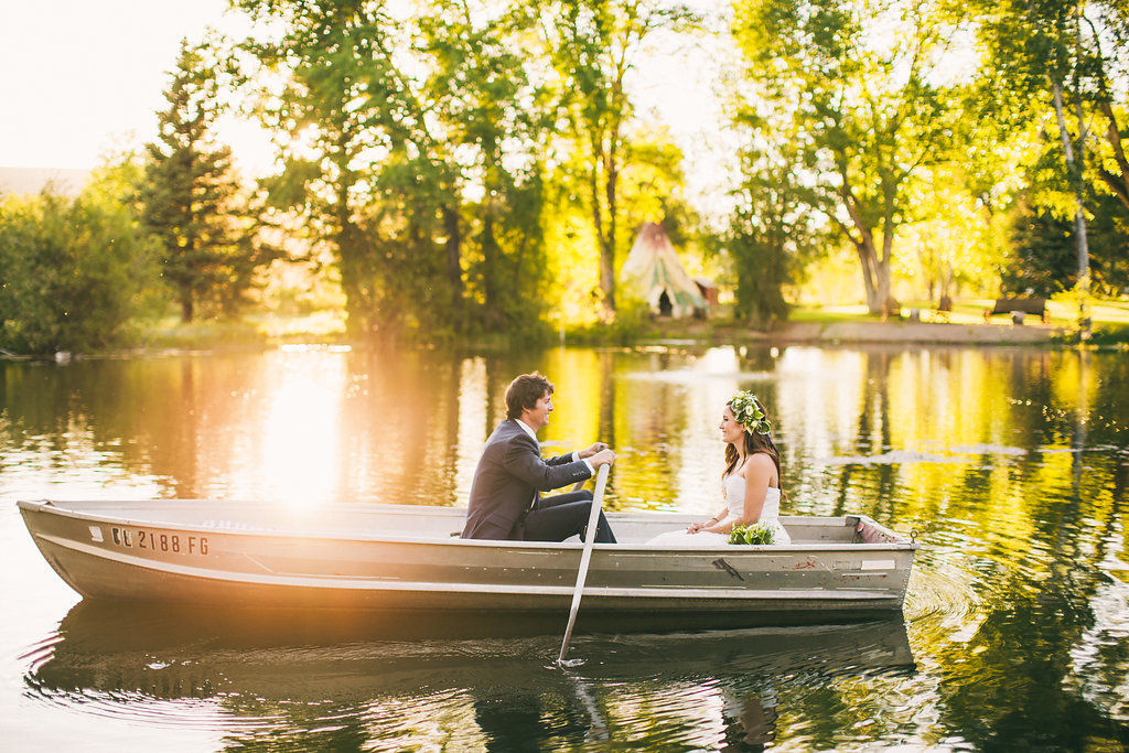 Wedding row boat on a lake. Sunset shining through trees