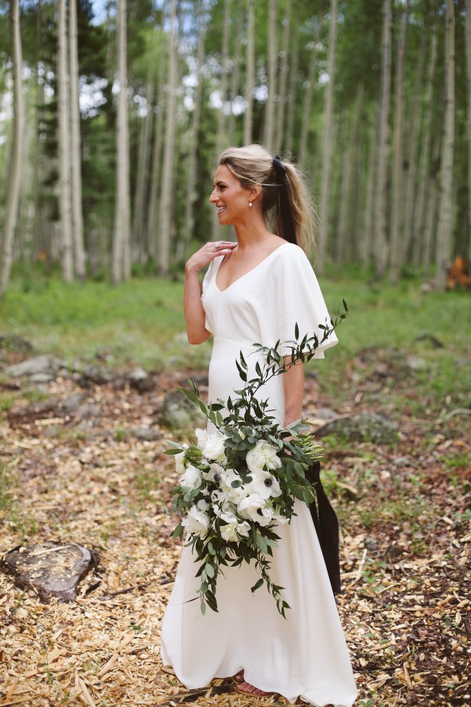 Sarah Seven wedding dress with long black ribbon and white wedding bouquet