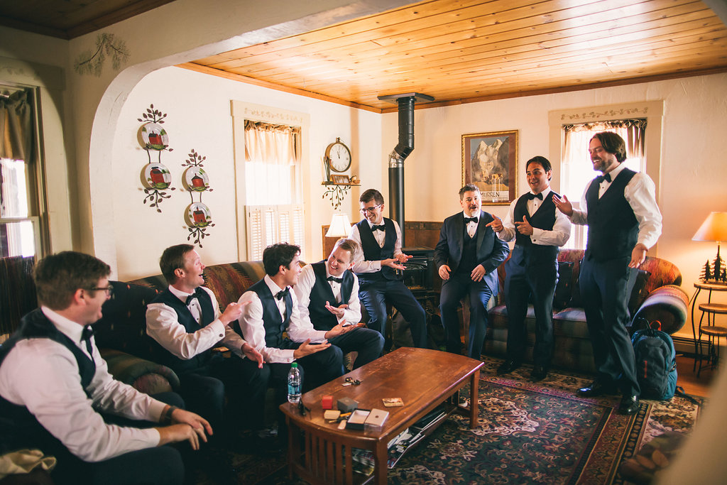 Groomsmen all getting ready together in a cabin