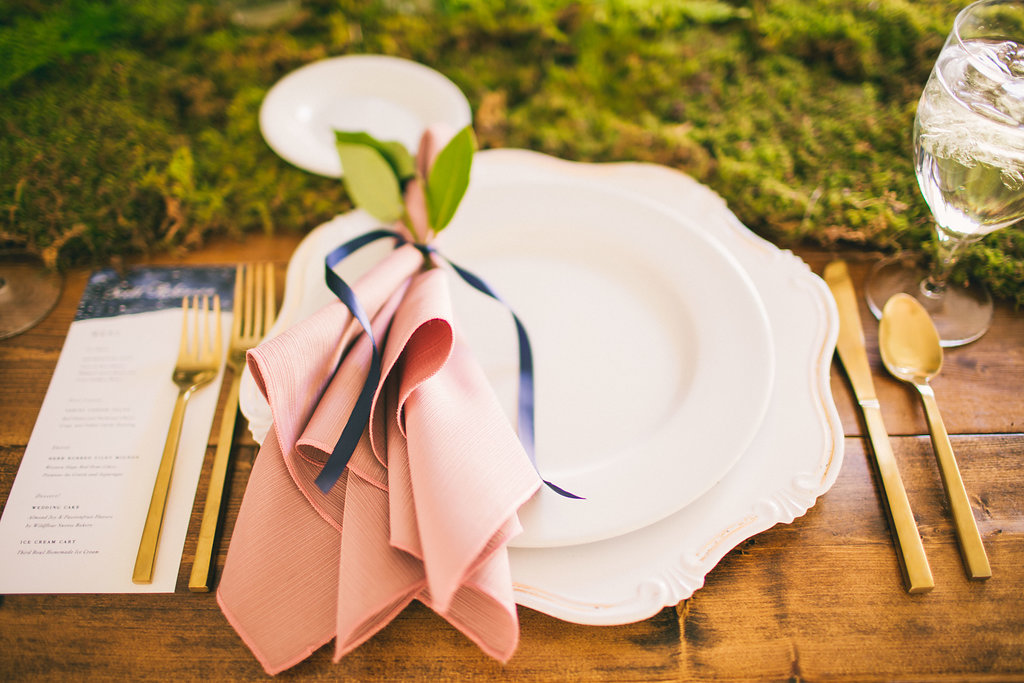 table setting for white plate and gold flatware