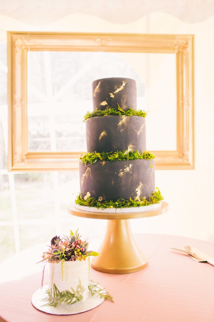 Navy and gold wedding cake with moss